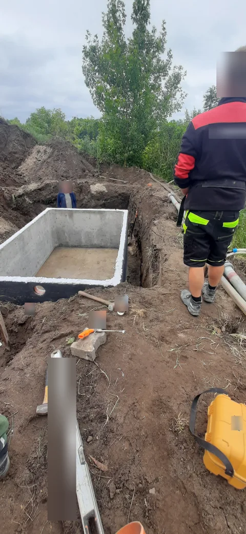 Osadzanie betonowego zbiornika na deszczówkę w wykopie — Łódź.